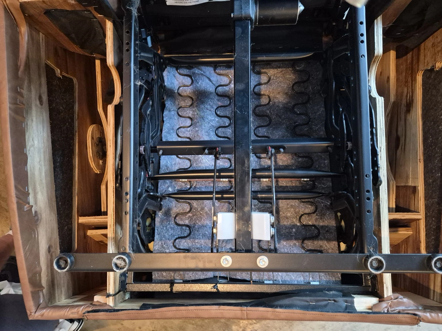 Actual underside photograph showing the recliner’s frame, springs, crossbars and mechanism.